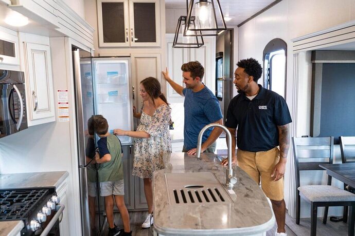 Family looking at refrigerator inside RV