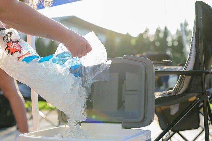 Person adding ice to cooler for tailgating
