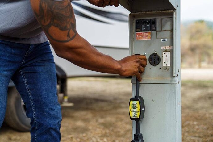 Man plugging surge protector into power pedestal