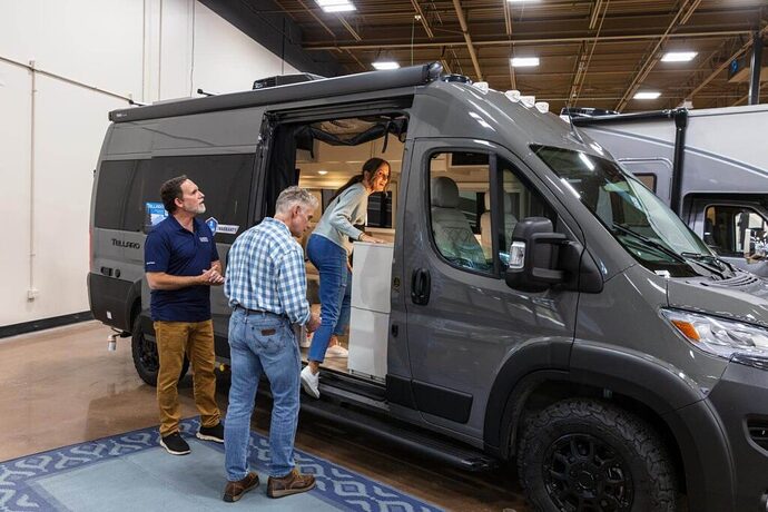 Couple touring camper van at an RV dealership