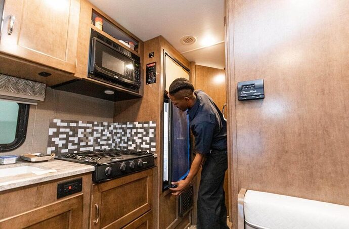 Technician inspecting RV fridge