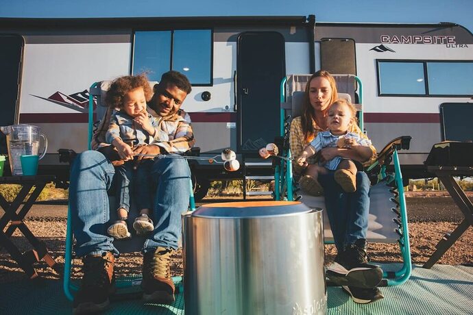 Family with kids sitting in front of their Campsite Ultra travel trailer