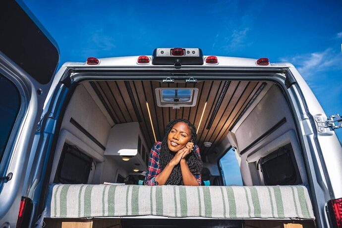 Woman on a bed in the back of a Class B