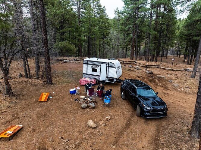 An SUV and camper at a campsite. 