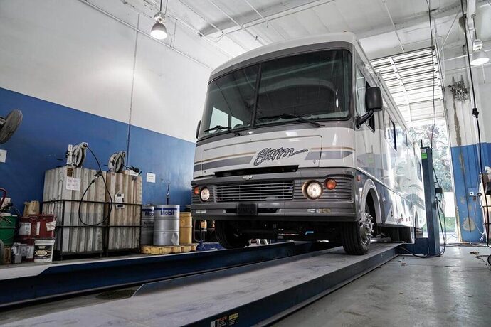 Motorhome driving onto lift at RV service center