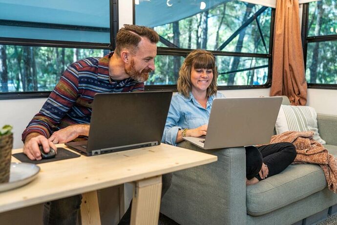 Couple doing remote work at their DIY RV workstation