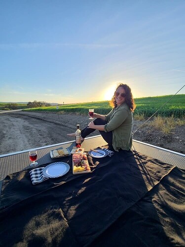 Woman drinking wine sitting on patio of 2020 Forest River EVO toy hauler