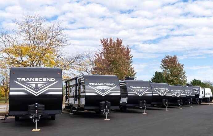 Several small campers in a row at a dealership