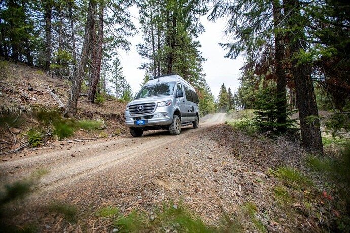 Thor Eddie Bauer Class B RV driving down dirt road
