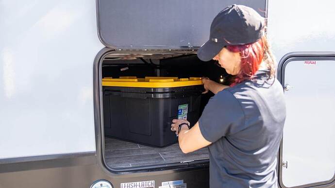 woman removing bins from camper storage