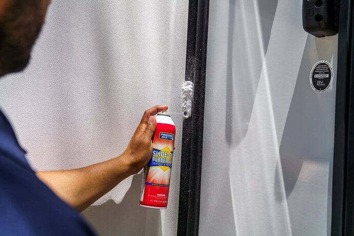 Man applying lubricant to RV slide seals