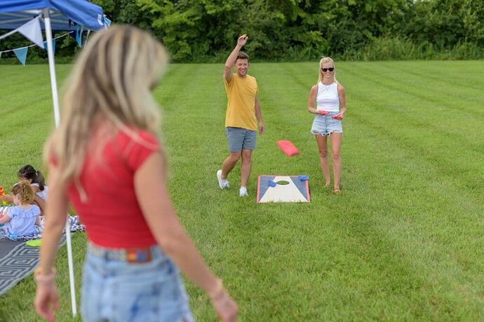 family RV tailgate party with cornhole game