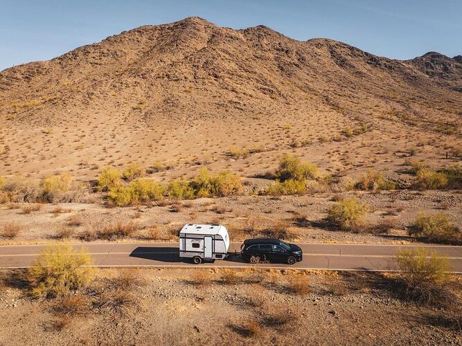 Small micro camper RV towed in the desert. 