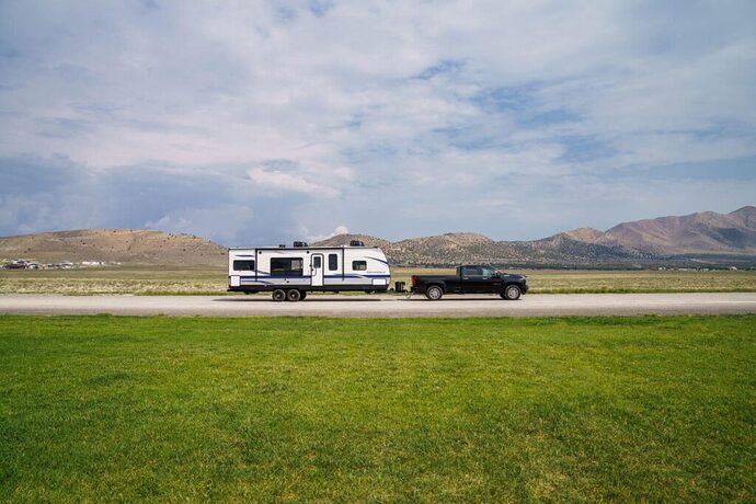 Truck towing travel trailer down road