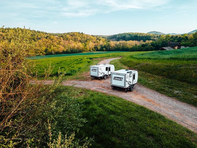 Two micro campers in a field. 