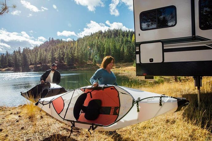 Couple carrying collapsible Oru Kayaks