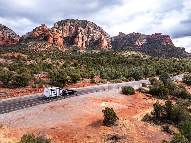 Lone travel trailer being towed through a desert landscape
