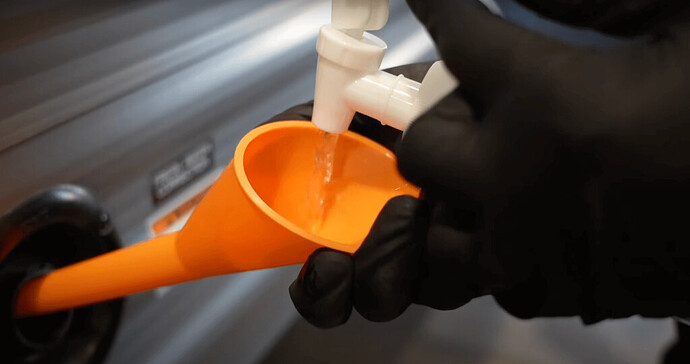 pouring diluted bleach solution into rv fresh water tank inlet with funnel