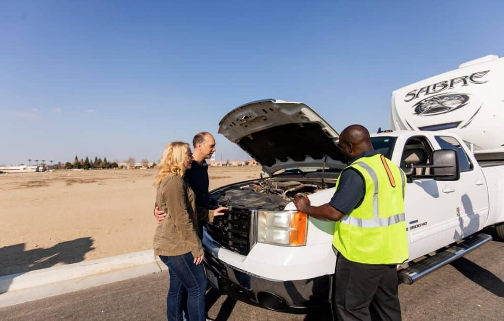 Roadside assistance tech inspecting vehicle
