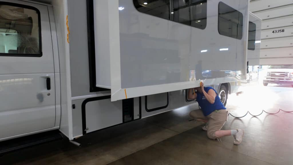 Technician evaluating slide mechanism for RV construction methods