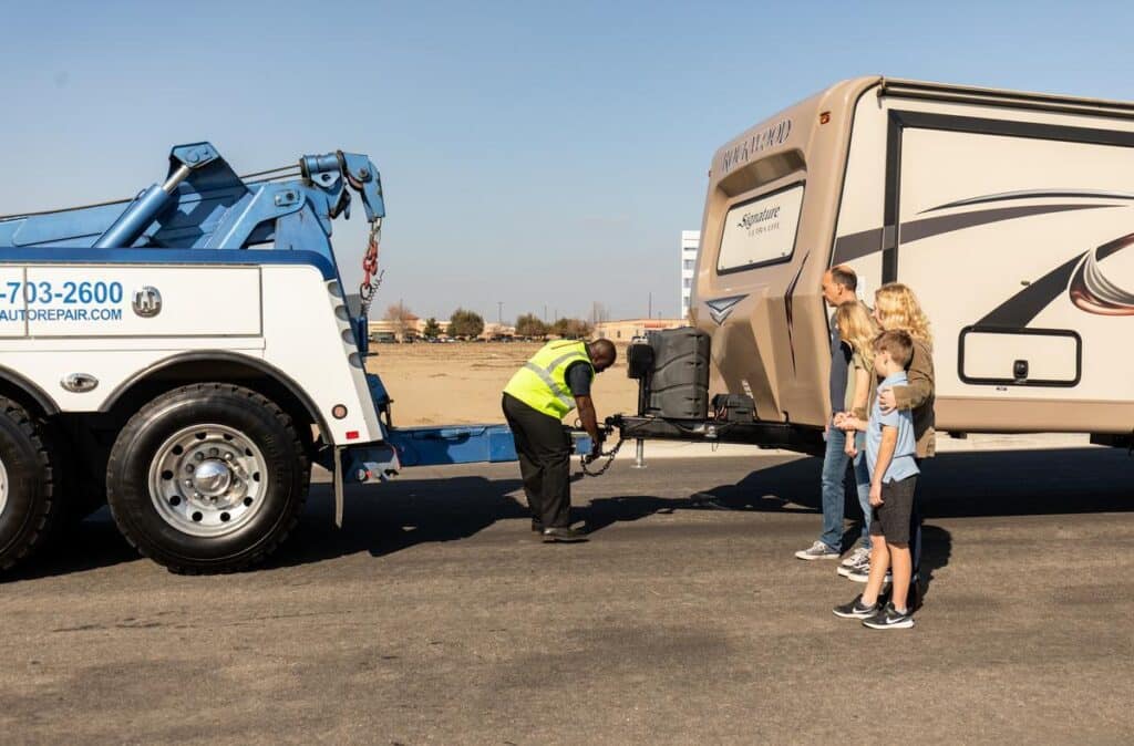 RV being hooked up for towing by a roadside assistance technician